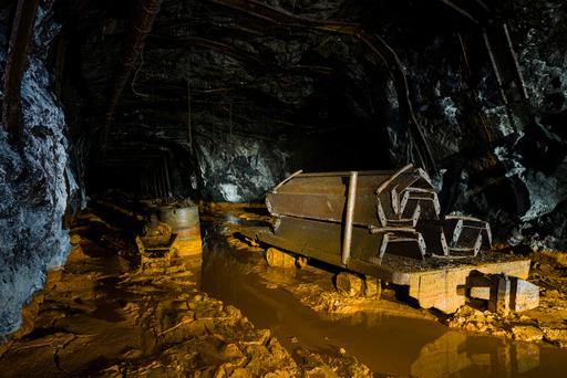 This flatcar sits abandoned in deep muck carrying coal chutes. The mine extends on in the distance seemingly forever, and there is some miscellaneous mechanical components just beyond the flatcar. This mine was excruciatingly long difficult to traverse; the muck was as much as 24-30 inches at its worst. This photo was taken towards the end of the trip, at which point we had already trudged 4 miles through deep mud and water.