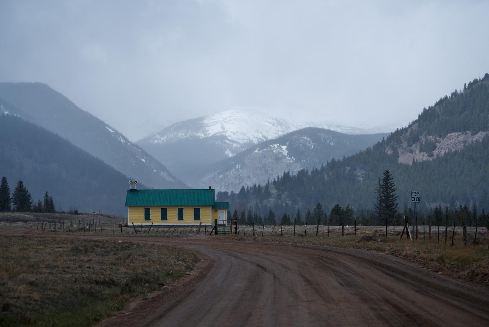 The Tolland School House sits disused in a Rocky Mountain valley.